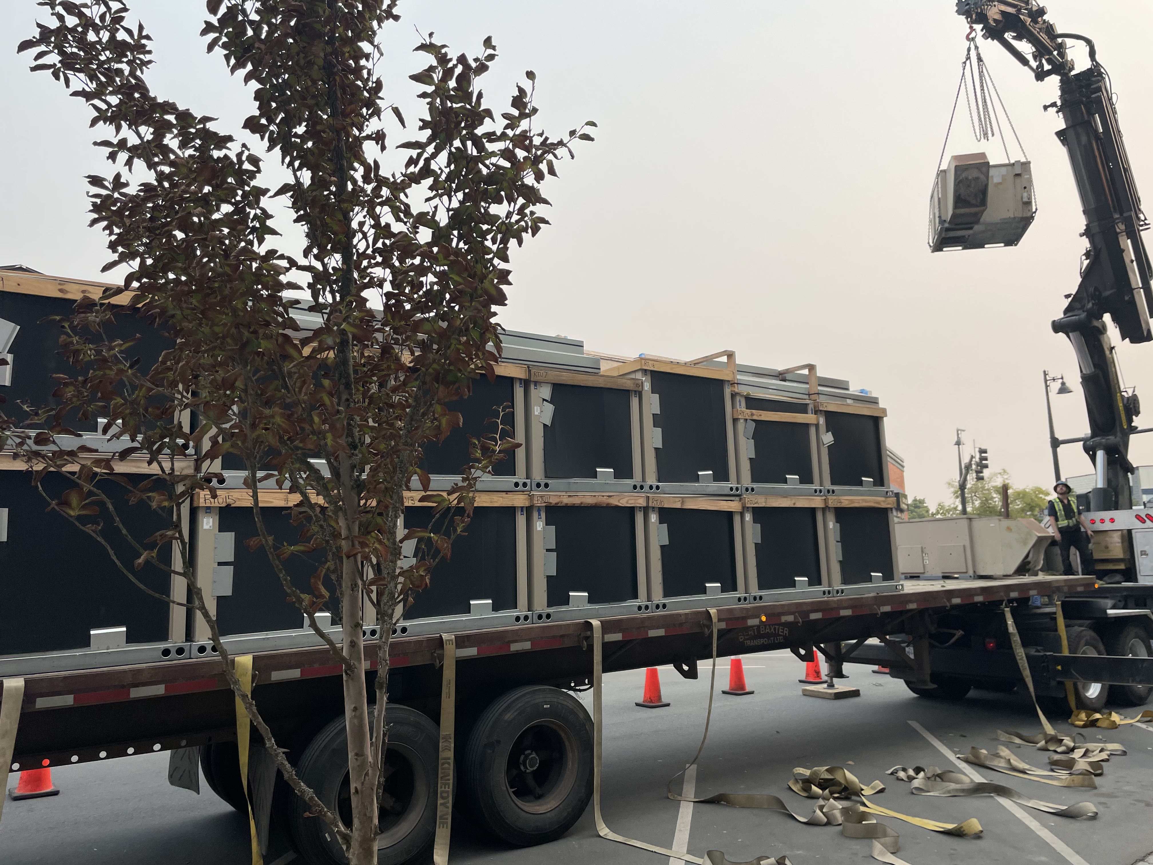 Commercial HVAC units being crane-lifted for rooftop installation by Alpine Refrigeration