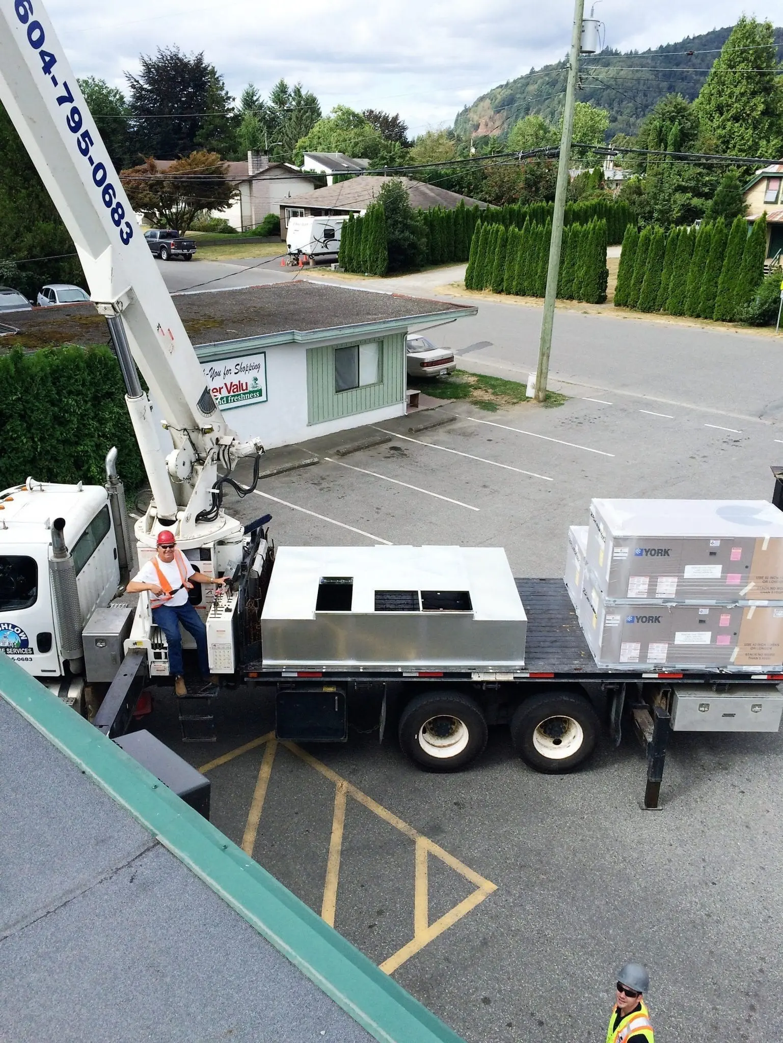 Alpine Refrigeration crane lift installing York HVAC rooftop units