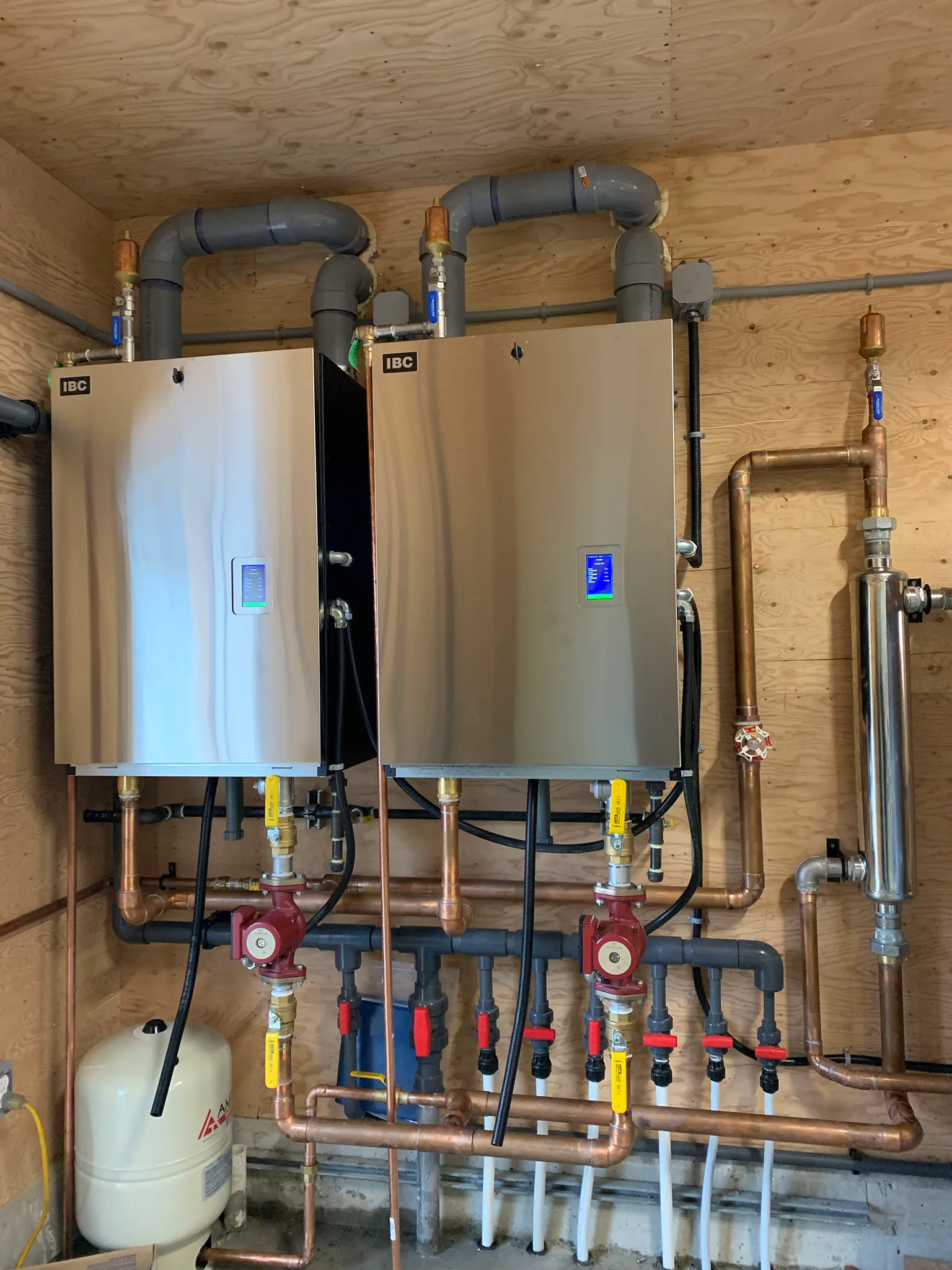 Dual IBC condensing boilers with copper hydronic manifold and circulators in a Fraser Valley mechanical room