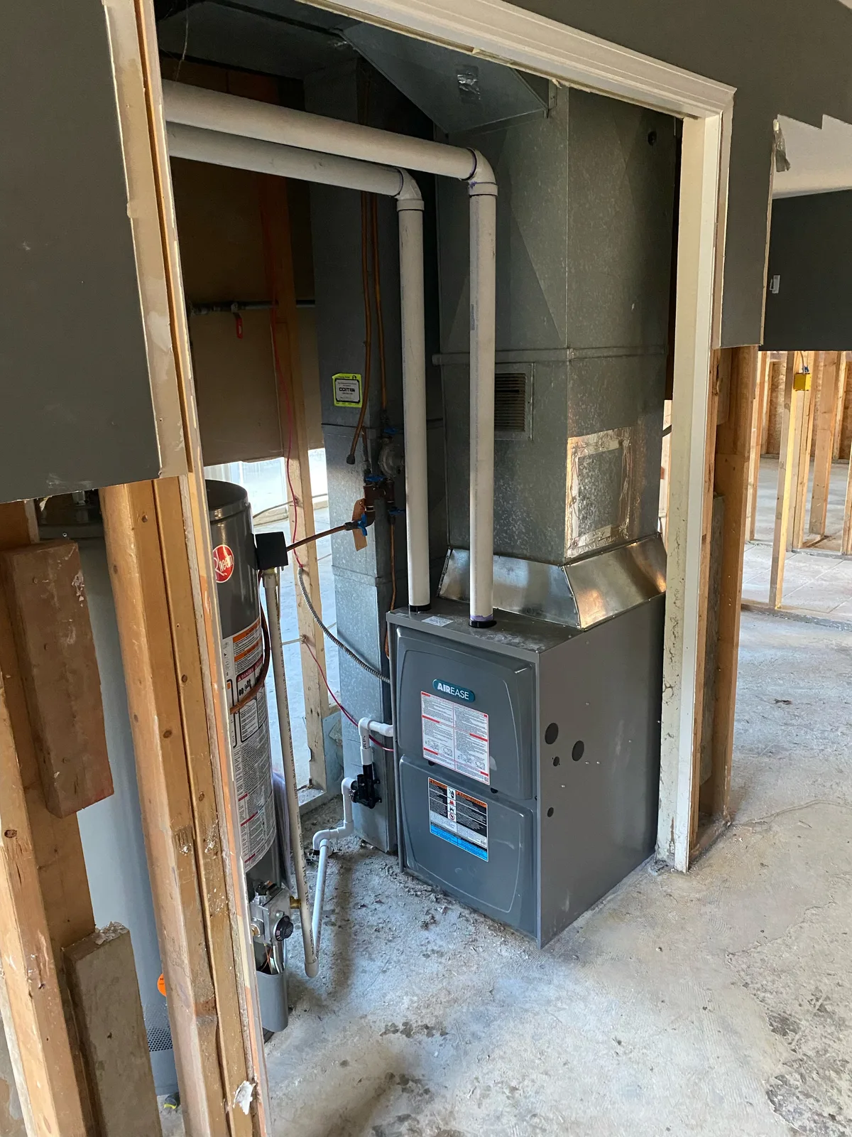 AirEase gas furnace installation in new residential construction with ductwork and water heater