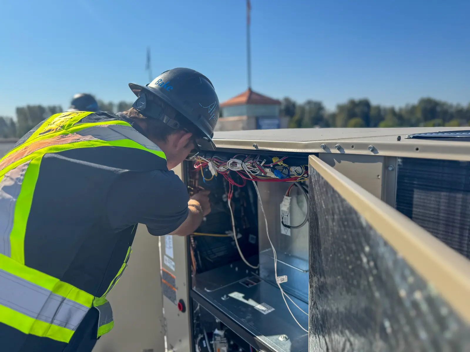 Alpine technician wiring the rooftop unit controls on the London Drugs dual-fuel retrofit in Mission, BC