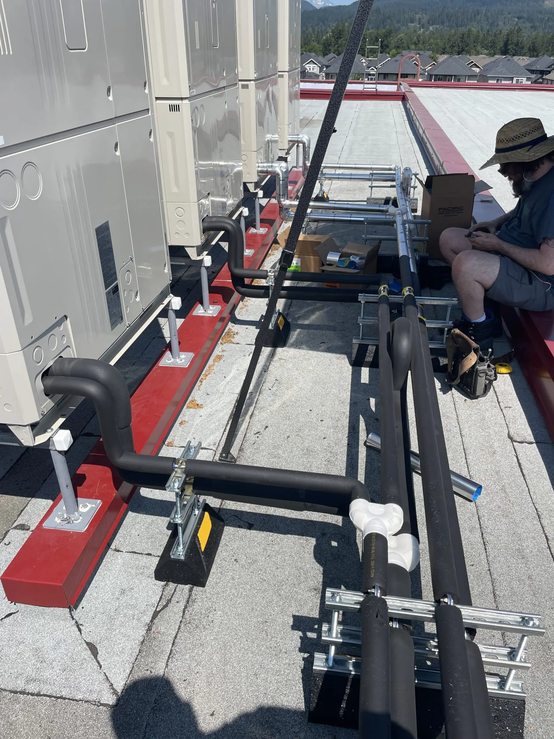 Aluminum-jacketed refrigerant lines protecting insulation from bird damage at Mission Schools SD75 hybrid heat pump retrofit Fraser Valley BC