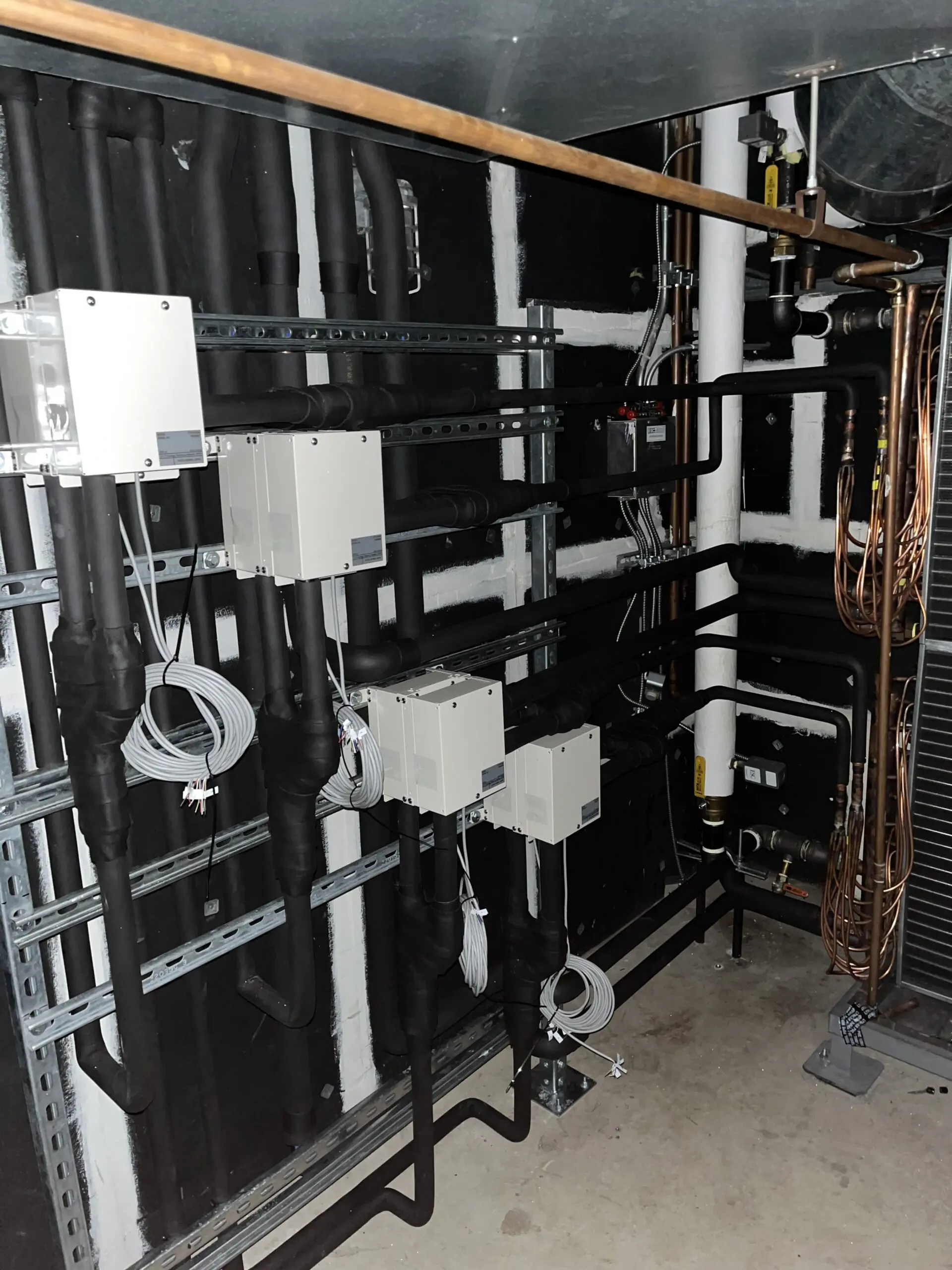 Electronic expansion valve racks inside Mission Schools air handler for hybrid heat pump retrofit.