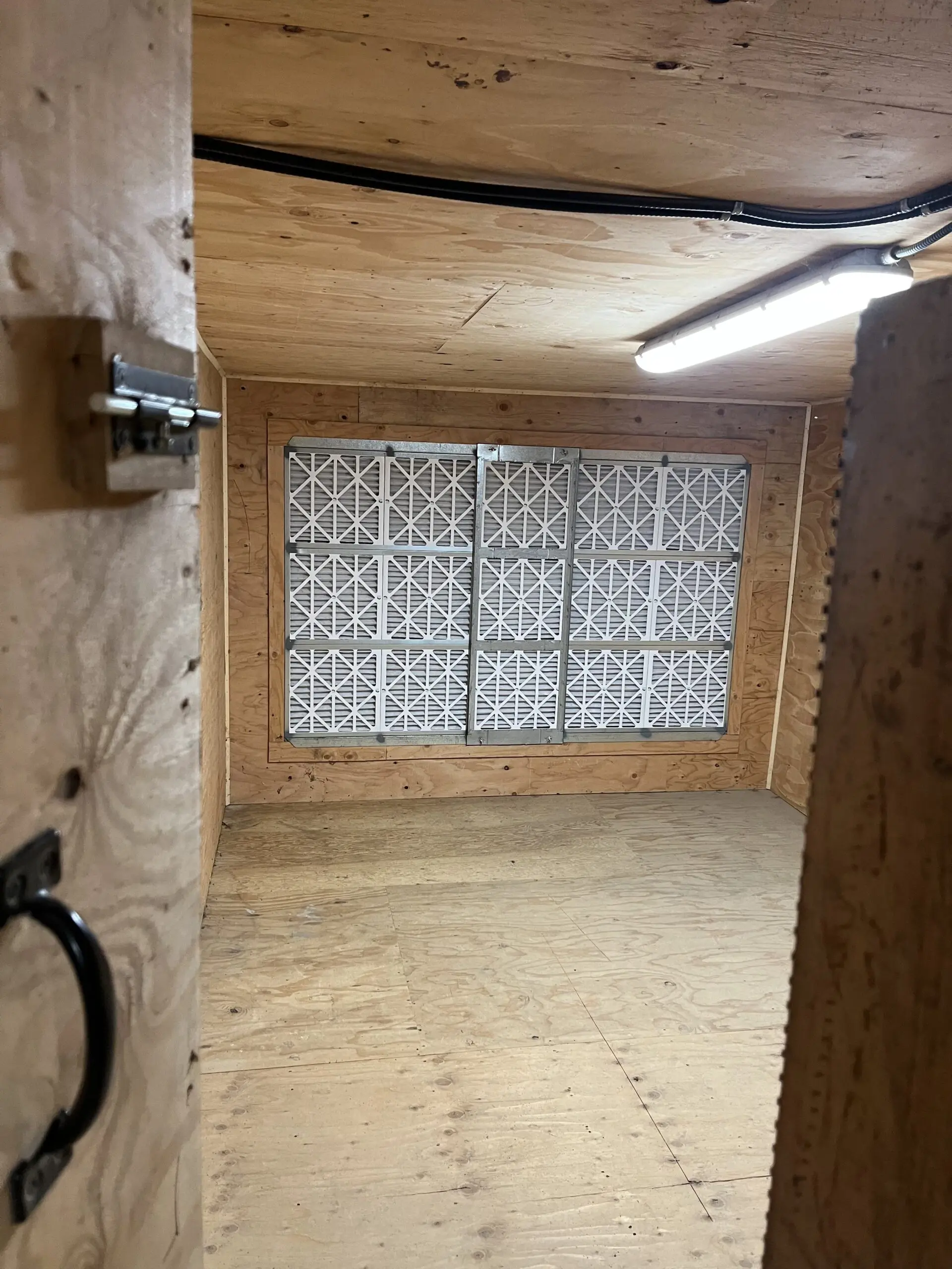 Wood-paneled farm building interior retrofitted with Alpine Refrigeration HVAC coils